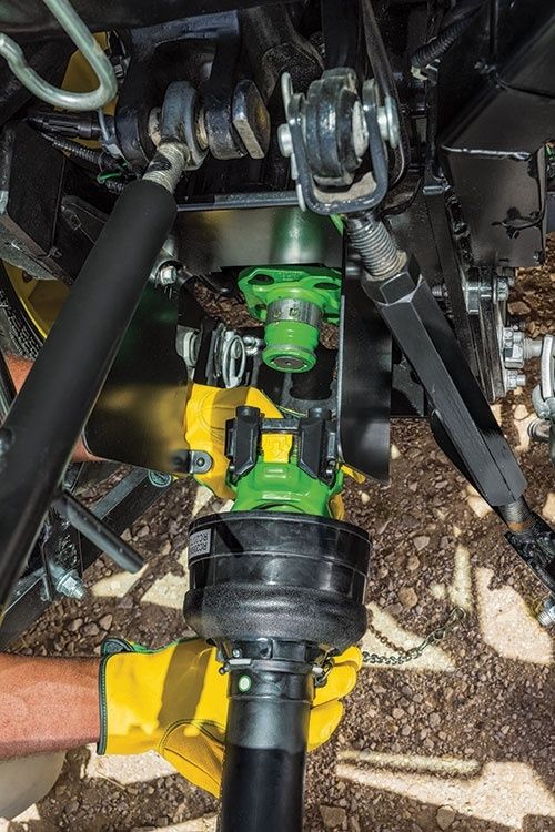Närbild av kraftöverföringsaxel och trepunktskoppling på en traktor